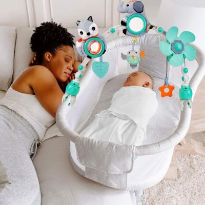 Bébé dort avec mobile bébé clipé au couffin près maman