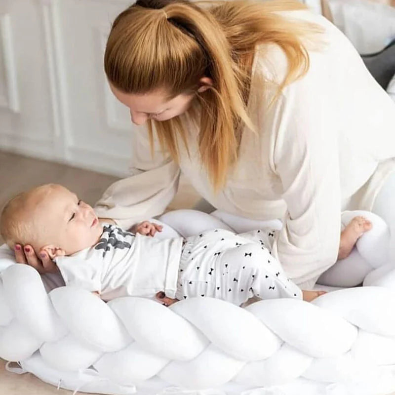 Cocon-pour-bebe-tressé-blanc-avec-maman-qui-y-dépose-son-bébé