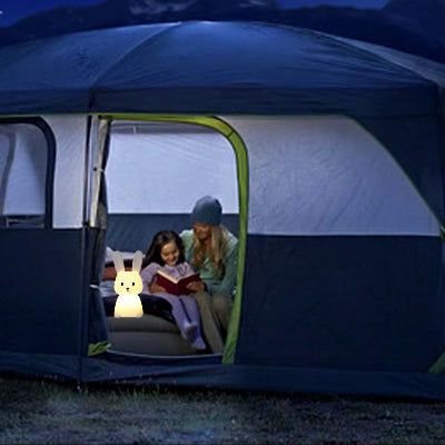 veilleuse-bunny-allumé-dans-une-tente-avec-maman-qui-lit-une-histoire-a-sa-fillecamping