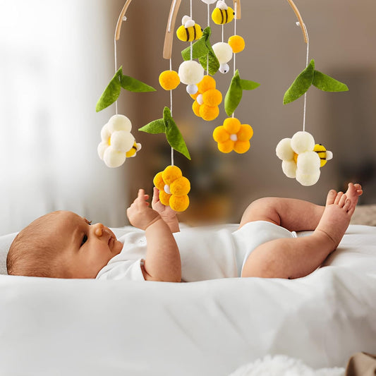 bébé qui touche délicatement les fleurs de son mobile