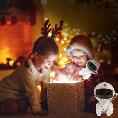 Enfant qui ouvre cadeaux noêl découvre veilleuse astronaute