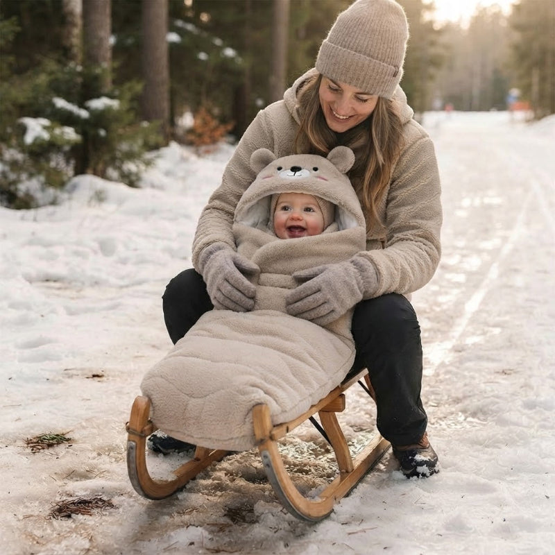 Bébé dans la luge en fin d'hiver dans son nid d'ange bebe avec maman
