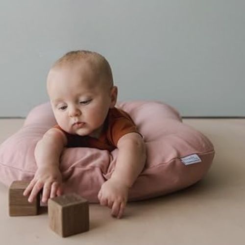 Bébé s'amuse à plat ventre dans son reducteur de lit mini rose