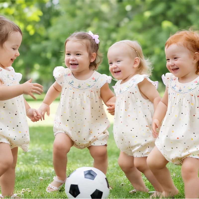 4 amies jouent aux ballons dans leur barboteuse bébé fille 