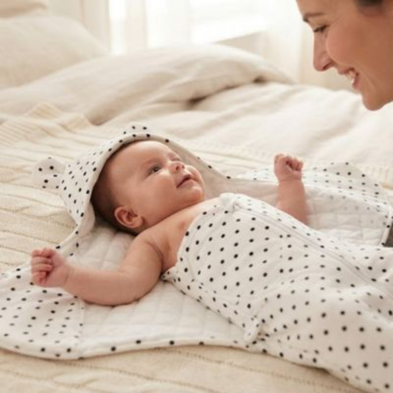 Bébé dans son nid dange bebe sur lit avec maman