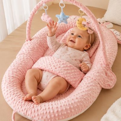Fillette dans son cocon bebe qui s'amuse avec mobile