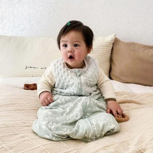 Bébé sur lit maman dans sa gigoteuse bébé hiver
