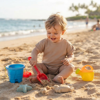 Léo dans sa barboteuse bebe s'amuse dans le sable
