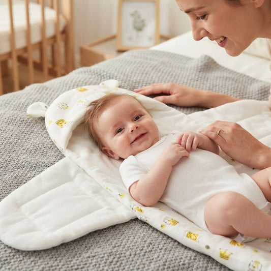 Lucas sur son nid d'ange qui sourit maman