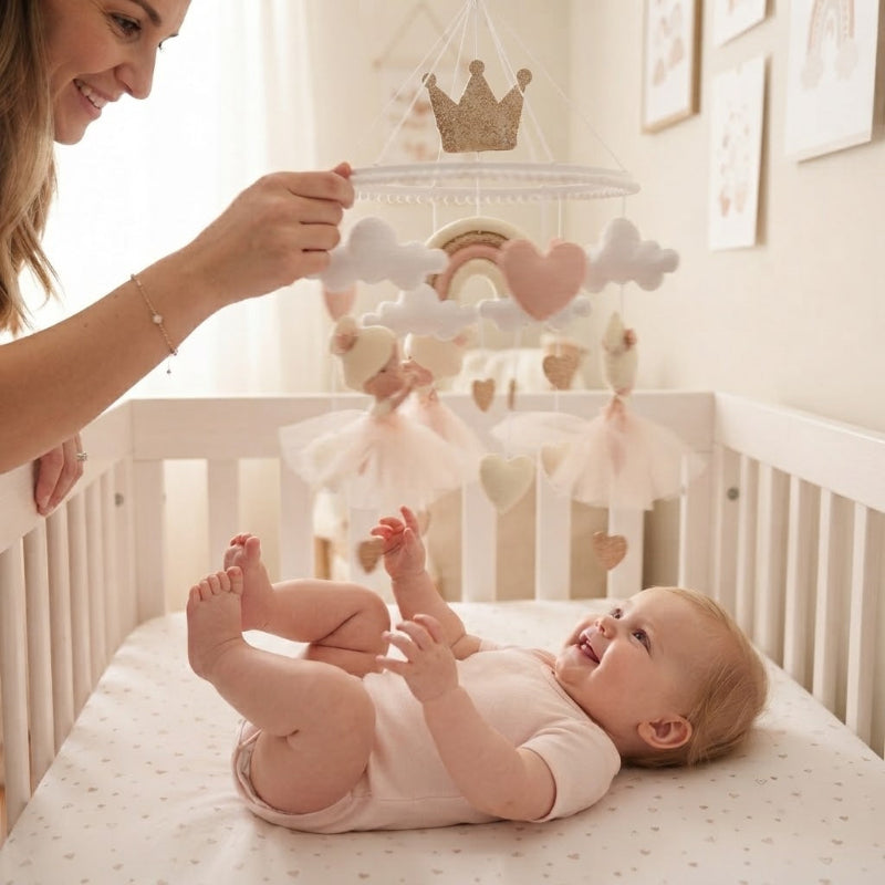 Maman fait tourner mobile bébé fille au dessus de bébé