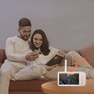 Parents qui regardent bébé sur moniteur du meilleur babyphone