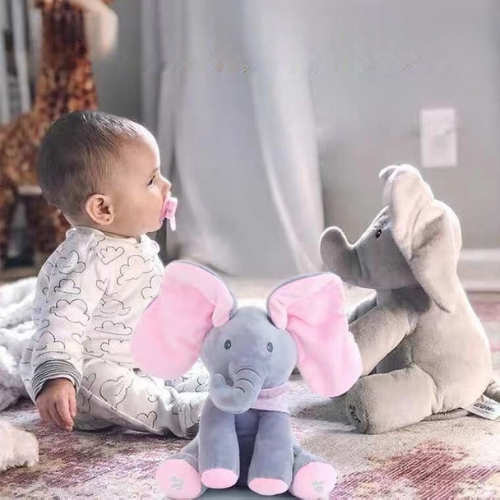 Peluche éléphant rose qui cache ses yeux avec ses oreilles et qui joue de la musique