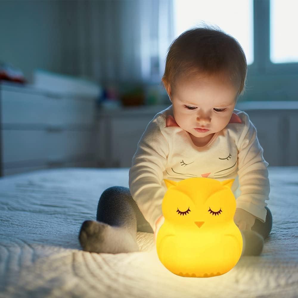 veilleuse-bebe-hibou- allumé-sur-un-lit-avec-un-bebe-captivé