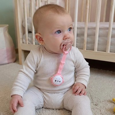 accroche tétine rose sur pyjama bébé