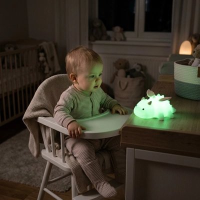 bébé assis chaise haute captivé par la veilleuse verte sur la table