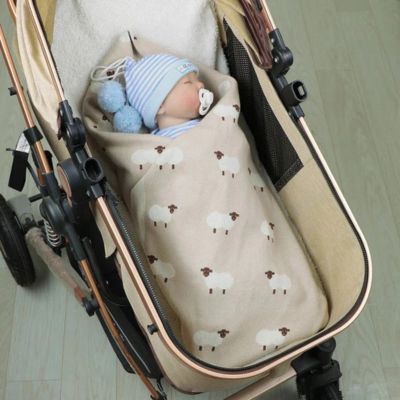 bébé dans poussette couvert par couverture bebe moutons