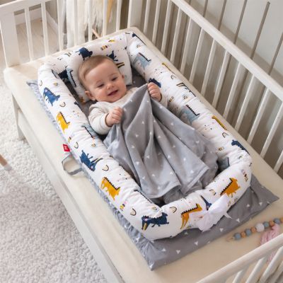 bébé joue avec couverture dans reducteur de lit crocodile