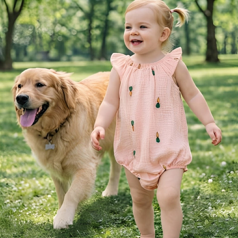 Fillette dans barboteuse bébé fille cour au parc avec chien