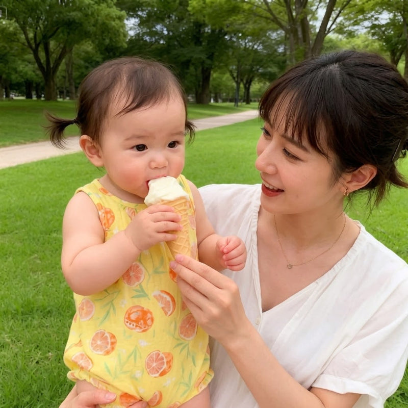barboteuse fille jaune mange crème glacée avec maman