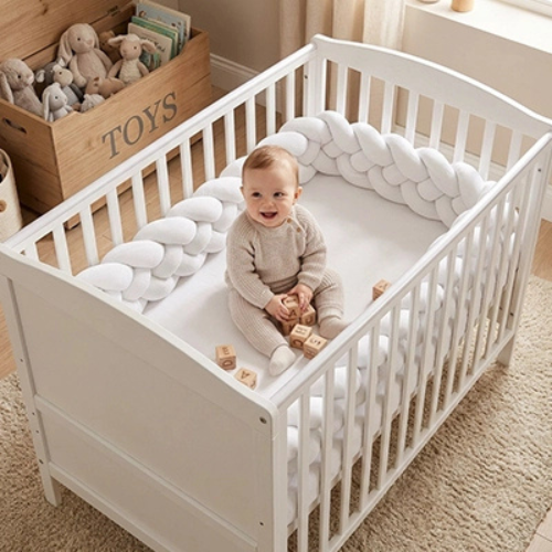 bébé assis dans berceau entouré tresse de lit