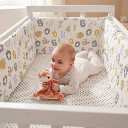 bébé avec sa doudou dans berceau avec tour de lit bebe