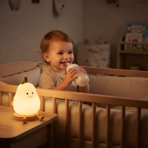 bébé dans son lit avec biberon et veilleuse poire