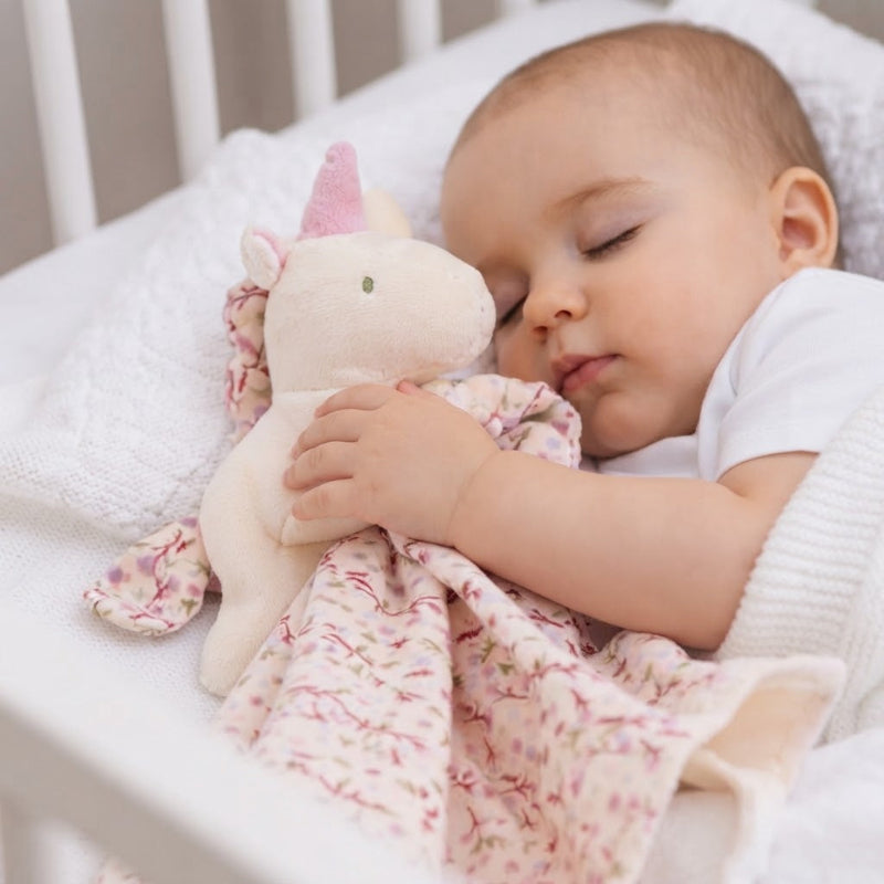 Bébé dort avec doudou licorne