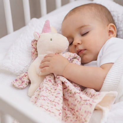 Bébé dort avec doudou licorne