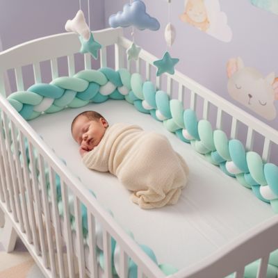 bébé dort dans berceau entouré tresse de lit verte-blanche