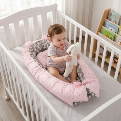 Bébé parle peluche dans réducteur de lit dans berceau