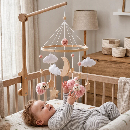 bébé qui attrape les moutons de son mobile bébé