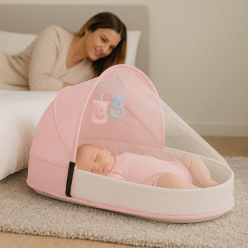 Bébé qui fait la sieste dans son réducteur de lit bébé près de maman