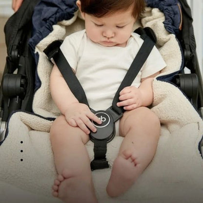 Bébé regarde la ceinture de sa chancelière poussette
