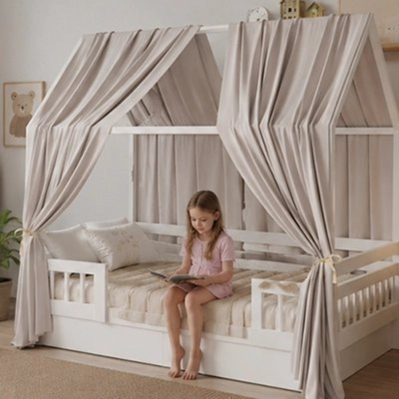 Ciel de lit cabane gris et petite fille assise sur son lit fait lecture