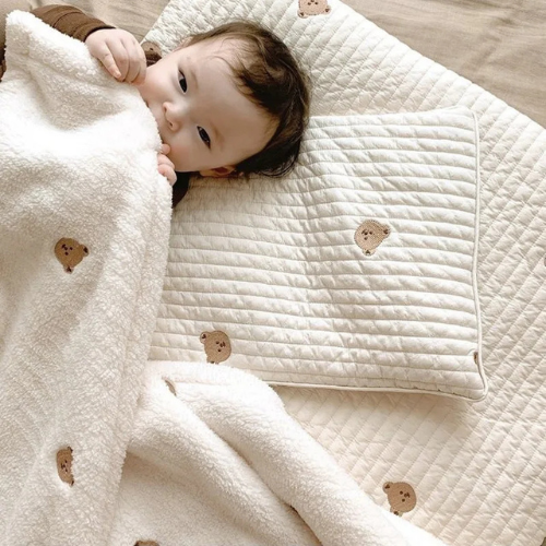 couette-pour-bebe-coton-blanc-avec-têtes-d'ours-et-bébé-dans-le-lit