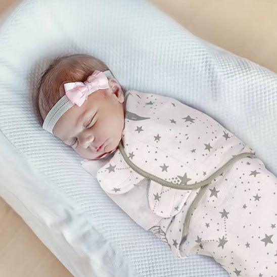 bébé-emmailloter-dans-une-couverture-étoilé-qui-dors