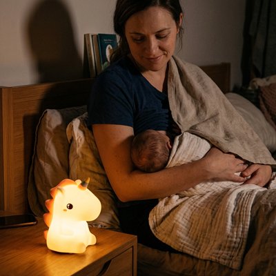 licorne veilleuse sur table éclaire bébé qui boit au seins