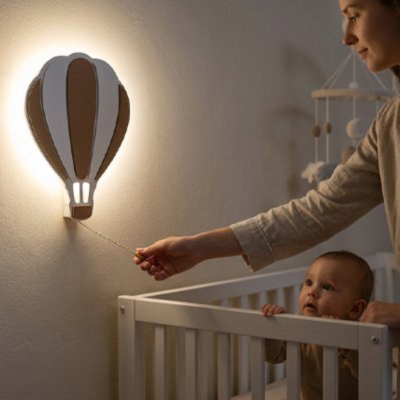 Maman allume la veilleuse murale bebe sous le regard de bébé