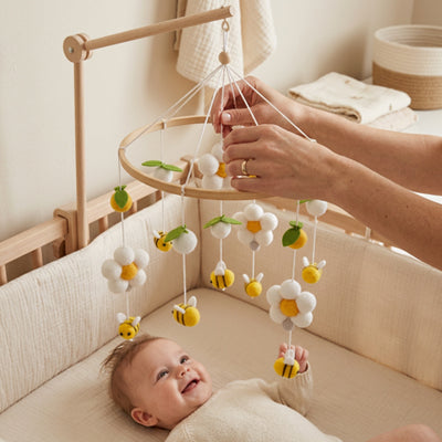 Maman fait tourner le mobile bébé pour que bébé content