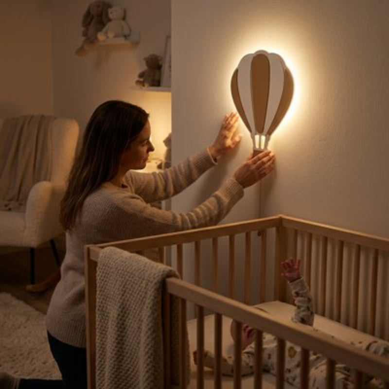maman qui ajuste la lumière de la veilleuse murale bebe