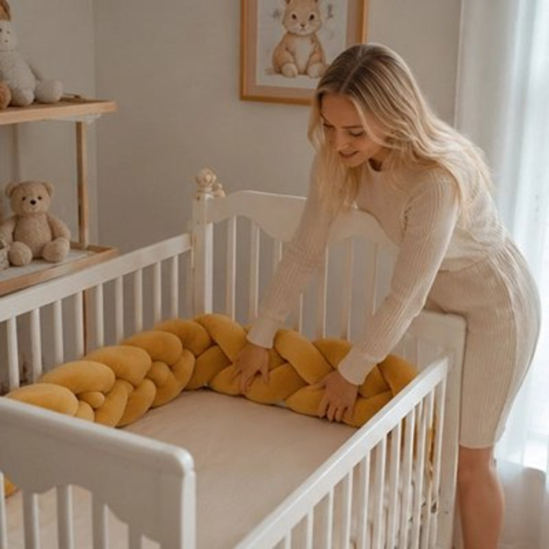 Maman qui installe le tour de lit tressé jaune dans berceau