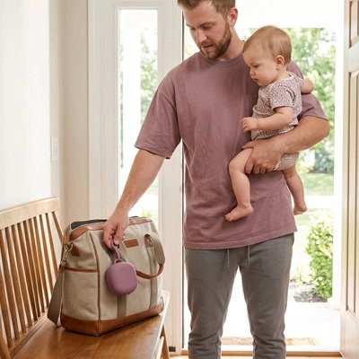 Papa accroche porte sucette son sac bébé dans bras