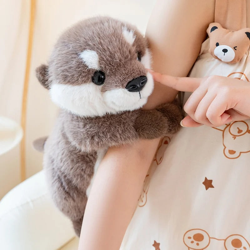peluche-loutre-aggripe-au-bras-bébé