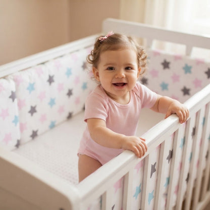 petite fille debout dans son berceau avec tour de lit bébé étoiles rose