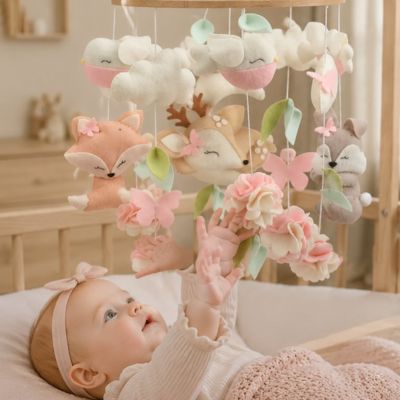 petite fille qui veut attraper son Mobile pour bebe