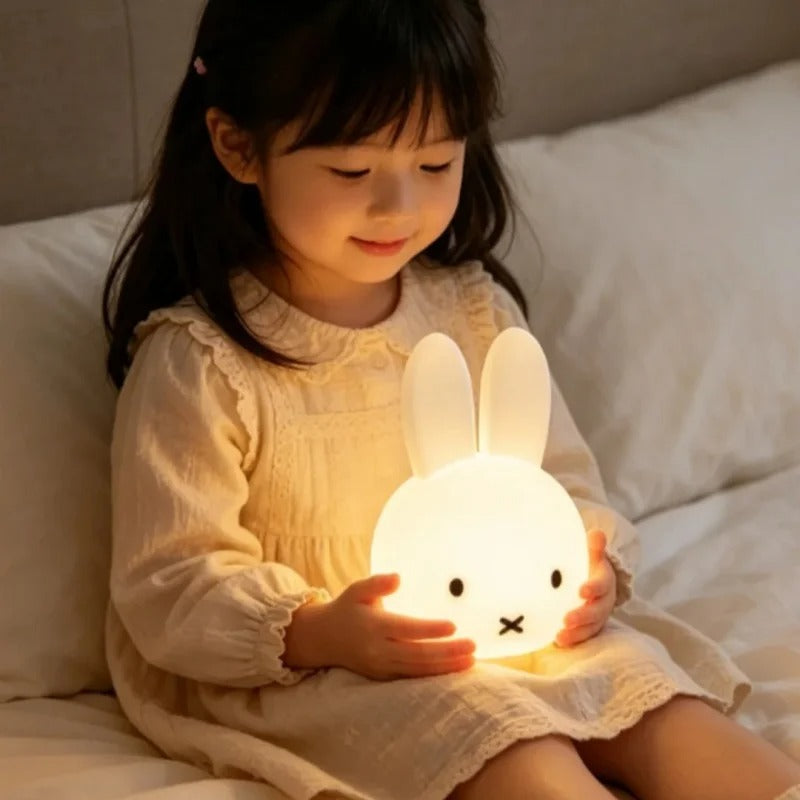 petite fille tient dans ses bras la veilleuse lapin