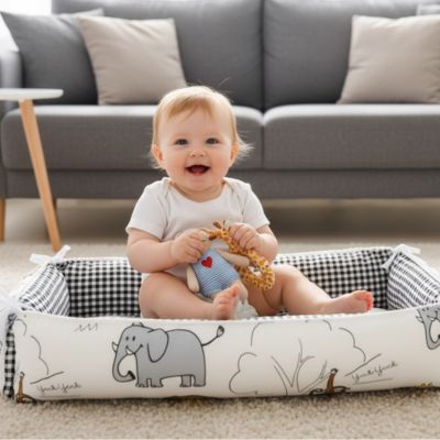 reducteur  de  lit  bebe assis qui s'amuse