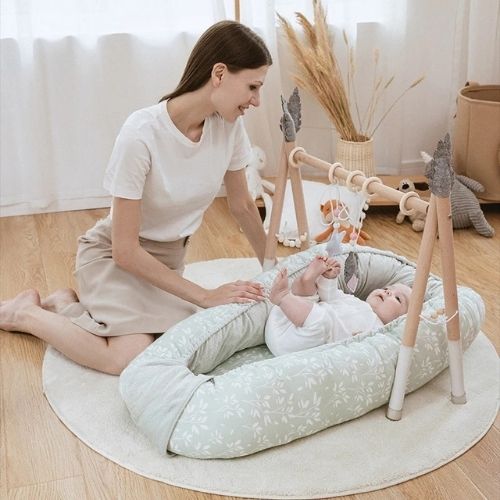 réducteur   de  lit  bébé  au salon avec maman et bébé qui  s'amuse