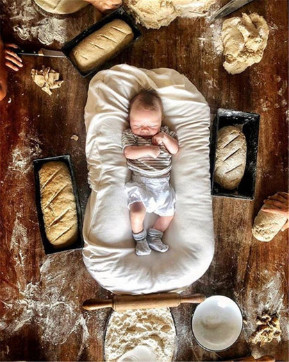 reducteur de lit blanc avec bébé dans la farine