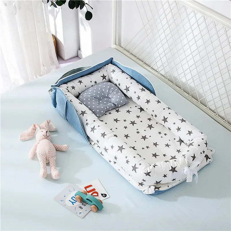 reducteur-de-lit-pour-bebe-ouvert-en-coton-déposer-sur-un-lit-contour-rigide-bleu-avec-housse- motifs étoiles-grise-sur-fond-blanc